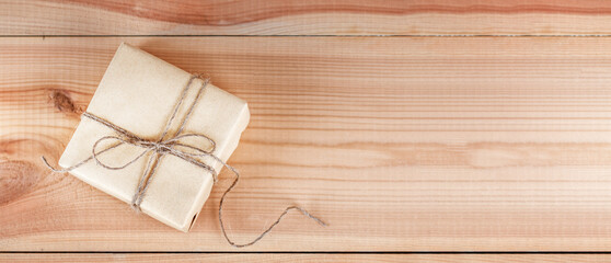 Top view of present box package with congratulation, wrapped brown paper on wooden table. Copy...