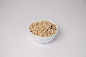 Sunflower Seed or Sunflower Seeds for eating on white bowl with white background, Sunflower Seeds or Sunflower Seeds for eating scattered on the white background in a wooden bowl.