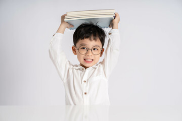 Portrait of an Asian boy studying on a white background