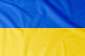 Flag of Ukraine with natural material creases as a background