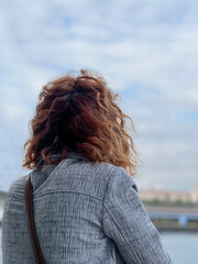 back portrait of a woman looking at view and sky