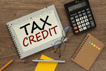 tax credits. gray notepad with text on the page. calculator