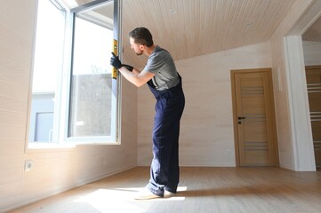 A worker installs windows in a new modular home. The concept of a new home.