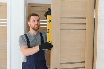 Young man fixing the door in house