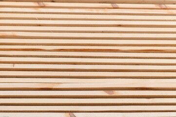 Stack of lumber of a wooden board from a tree, close-up, background. Wooden boards at the sawmill, carpentry workshop. Sawing and air drying of wood. Woodworking industry. Wooden boards