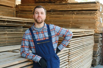 Carpenter in uniform check boards on sawmill