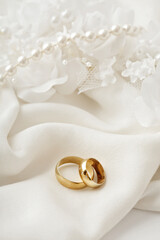 golden wedding rings, pearls and white flowers - 682235692