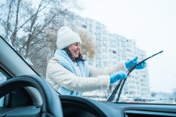 woman clean car out of snow