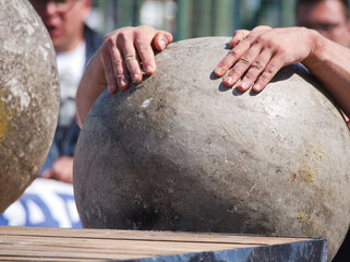 Muscular Man Lifting Heavy Concrete Ball