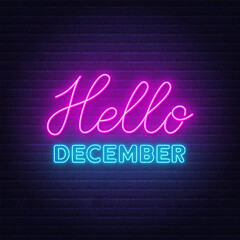 Hello December neon lettering on brick wall background.
