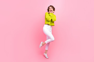 Fototapeta na wymiar Full length photo of good mood excited lady wear knitter pullover looking empty space isolated pink color background