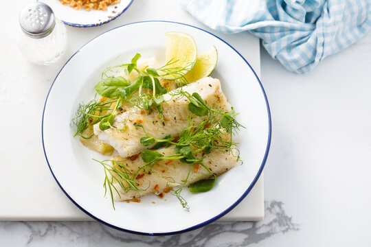 Baked white fish filet with green pea and lime