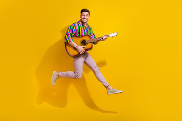 Fototapeta na wymiar Full size photo of young man professional coach music tutor jumping hold guitar instrument and jumping isolated on yellow color background
