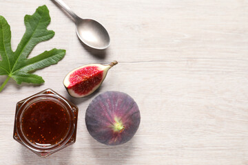 Jar of tasty sweet jam and fresh figs on white wooden table, flat lay. Space for text