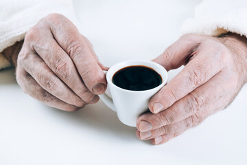 A cup of strong coffee in the hands of a man.