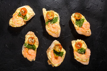 Starter or antipasto dish. Shrimp bruschetta sauteed in wine on French bread with Neapolitan sauce, basil, mozzarella cheese, cherry tomatoes