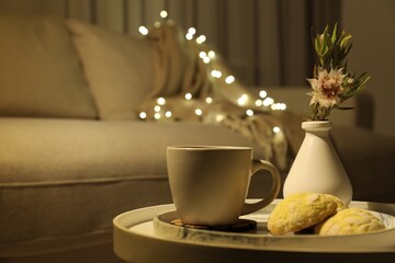 Cup of drink, cookies and vase of flowers on table indoors, space for text