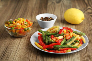Mix of different frozen vegetables on wooden table, closeup