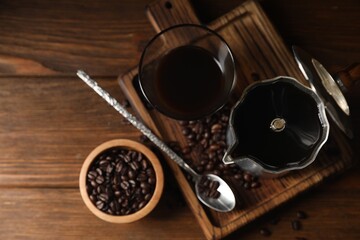 Brewed coffee, moka pot and beans on wooden table, flat lay