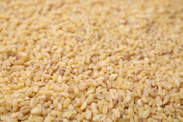 Uncooked organic bulgur as background, closeup view