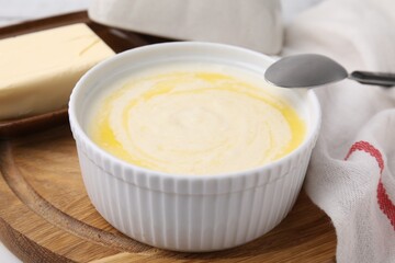 Bowl of delicious semolina pudding with butter served on table, closeup