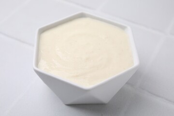 Bowl of delicious semolina pudding on white table, closeup