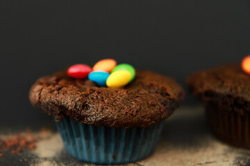Chocolate muffins. Sweet dark cookies with chocolate and cocoa powder. Homemade, freshly baked delicious cupcakes on the dark background