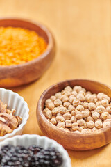 selective focus of wooden bowl with chickpeas near set of plant-based vegetarian food at home