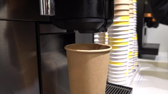 Stockholm, Sweden A person gets a coffee with milk from a coffee machine in a paper cup