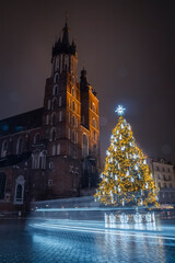 Kraków nocą w Święta Bożego Narodzenia z choinką świąteczną koło kościoła  Cracov by night ny Christmas withe the christmas tree next to church © Adrian White
