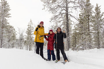 Family vacations, snowshoeing in snowy forests in Lapland