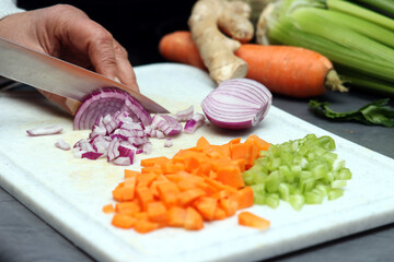 Frau schreidet rote Zwiebel in kleine Würfel