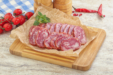 Sliced salami sausages over board