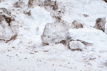 big snowball in the snow. snowball to make a snowman. make a big snowball. dirty snow. large block of snow on a snowy ground