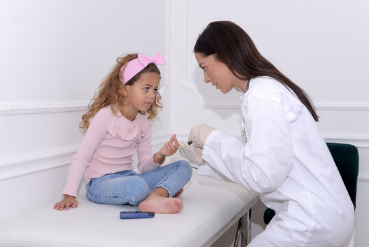 Doctor measures the sugar of a five-year-old child suffering from diabetes