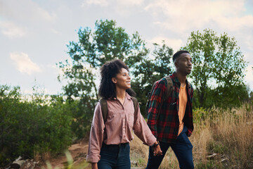 Smiling young multiethnic couple hiking together in some hills