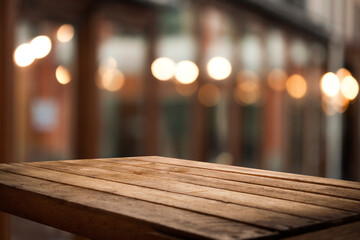 empty table to showcase your product on blurred golden bokeh cafe background. old wooden tabletop