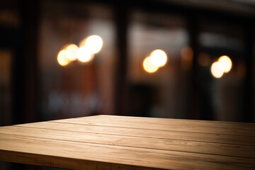 empty table to showcase your product on blurred golden bokeh cafe background. old wooden tabletop