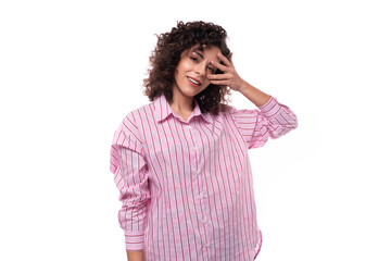 portrait of a 30 year old stylish slim curly brunette model woman dressed in a shirt with a striped print
