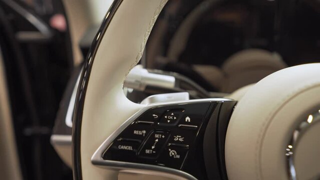 The steering wheel of the car is a close-up with the logo of the Mercedes automobile brand.