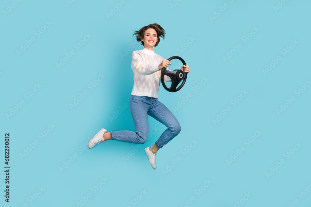 Sticker Full body photo of jump active young lady hold leather steering wheel volkswagen arteon fast speed driver isolated on blue color background