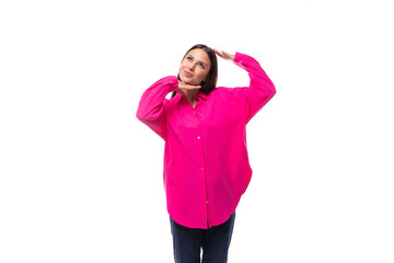 stylish charming young brunette in a bright pink oversized shirt on a white background with copy space