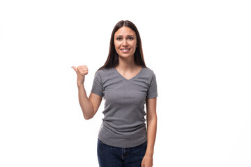 portrait of a caucasian slim young woman in a gray t-shirt pointing her hand at the wall