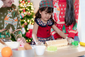 Kid and parent family celebrating xmas Christmas thanksgiving in dining room enjoy kneading cake dough together. People enjoy celebrate Christmastime holiday with yummy good taste food drink joy party