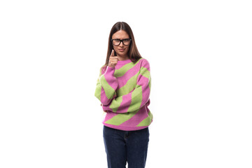 portrait of a smart young brunette woman in a casual stylish pink-green sweater on a white background with copy space