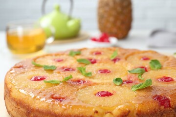 Tasty pineapple cake with cherries and mint on table, closeup