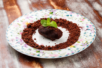 Traditional russian cake Kartoshka chocolate truffle sponge cake. Balls of vanilla biscuit with cocao powder, butter cream and nuts. Served on wooden background. Unbaked biscuit pastry.