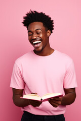 Cute African American young man smile, hold opened book, isolated on pink color background