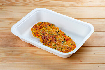 Vegetable pancakes. Healthy diet. Takeaway food. Ecological packaging. On a wooden background.