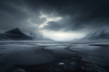  a black and white photo of a mountain range and a body of water in the foreground, under a cloudy sky with dark clouds, and snow - capped mountains in the background.